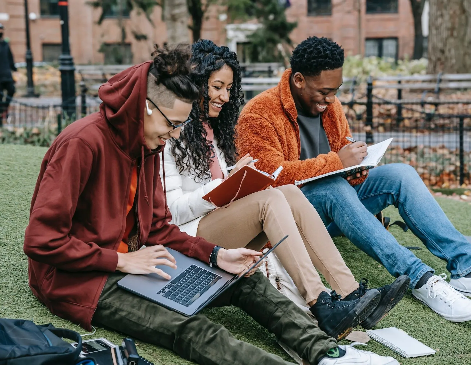 Students studying outside with laptops and notebooks, related to Viares clinical research courses.
